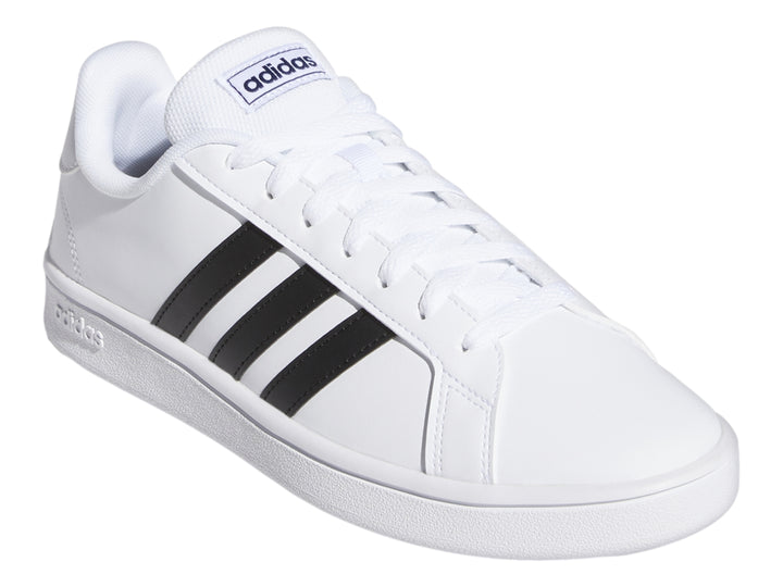 Tenis Adidas Grand Court Base en color blanco con tres franjas negras laterales y suela blanca.