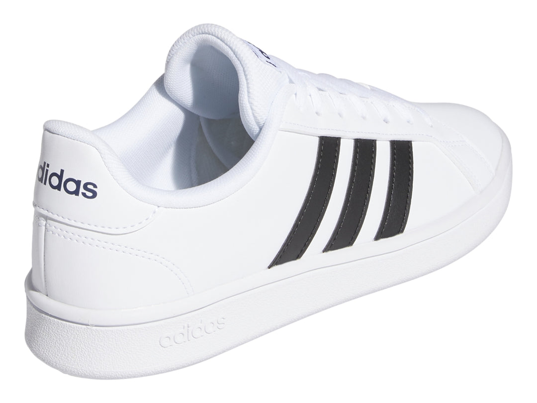 Tenis Adidas Grand Court Base en color blanco con tres franjas negras laterales y suela blanca.