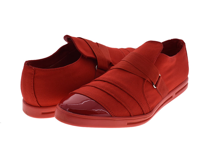 Zapatos rojos de lona para hombre con punta brillante y correas decorativas.