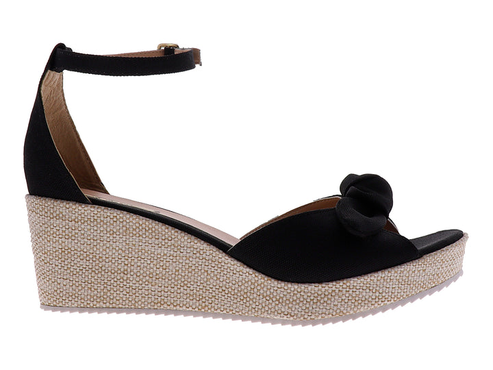 Sandalia de plataforma color negro con moño decorativo y suela de textura tejida en tono beige.