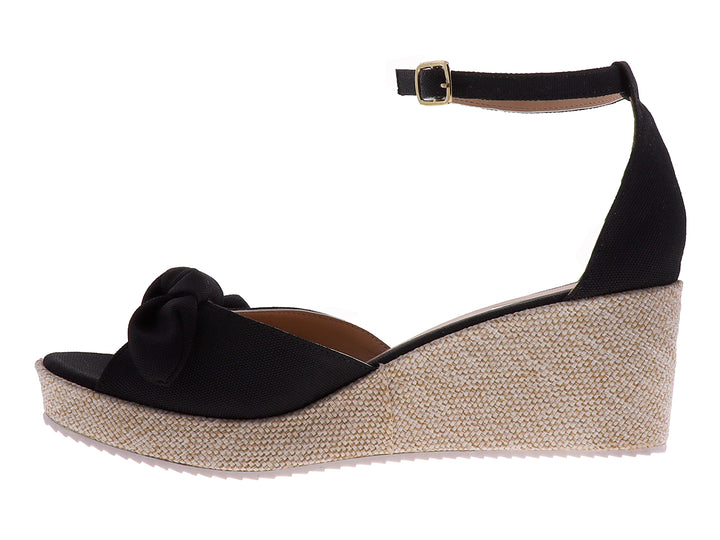 Sandalia de plataforma color negro con moño decorativo y suela de textura tejida en tono beige.