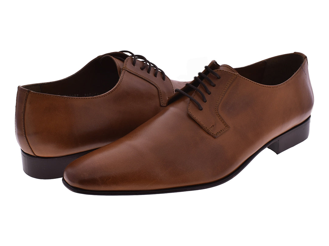 Zapato formal de cuero color naranja con cordones y suela marrón oscuro.