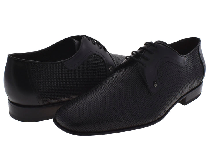 Par de zapatos negros para Hombre con textura y agujetas sobre fondo blanco.