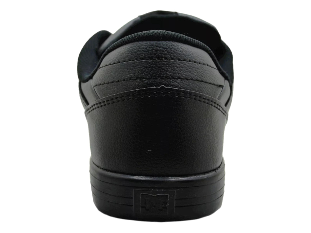 Tenis DC Shoes color negro sólido con suela plana y cordones.