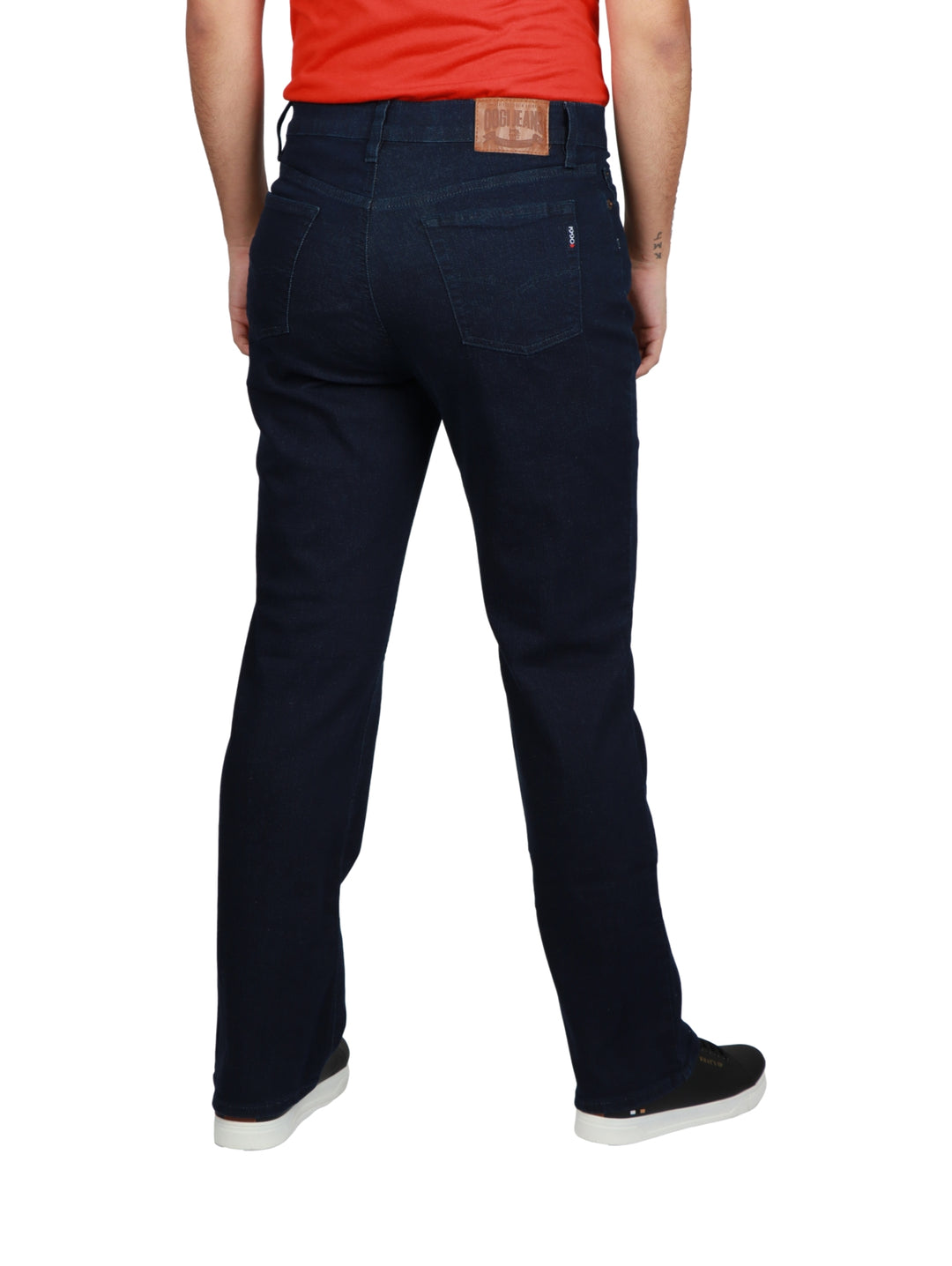 Hombre vistiendo pantalones jeans color azul oscuro Dark Indigo con tenis negros.