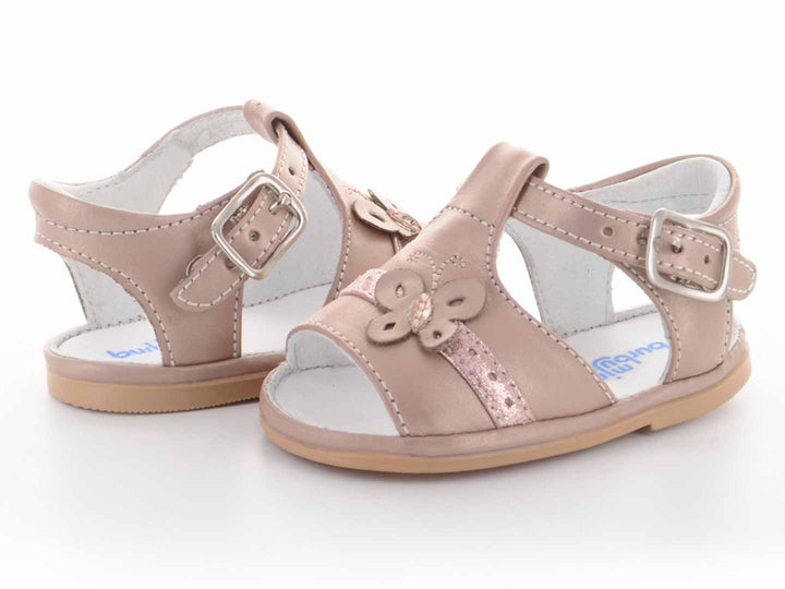 Par de sandalias color oro rosado para bebé con detalle de mariposa y hebilla.