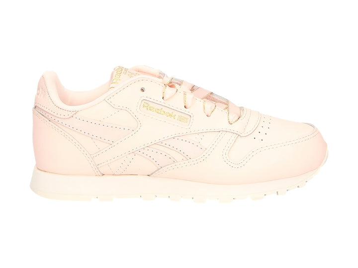 Tenis Reebok Classic Leather color rosa pálido con detalles dorados y suela blanca.