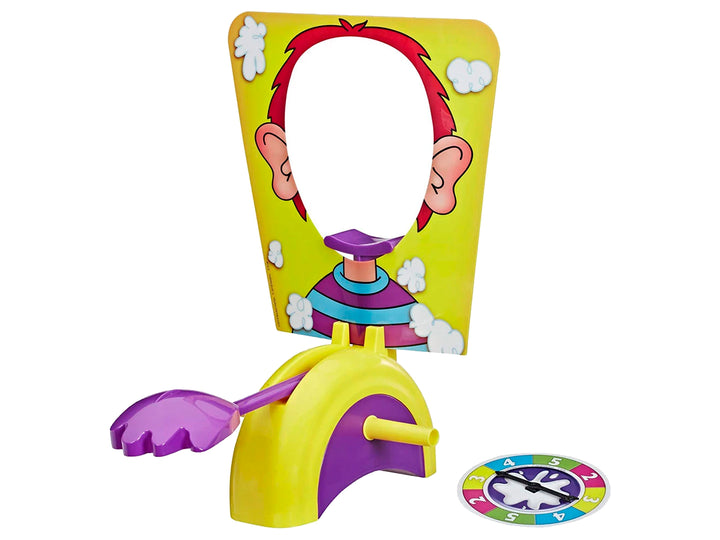 Caja del juego de mesa Pastelazo de Hasbro con fondo amarillo e ilustraciones de niños jugando.