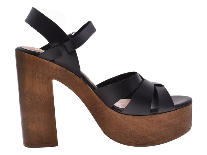 Sandalias negras de plataforma con tacón grueso de madera y correas con hebilla.