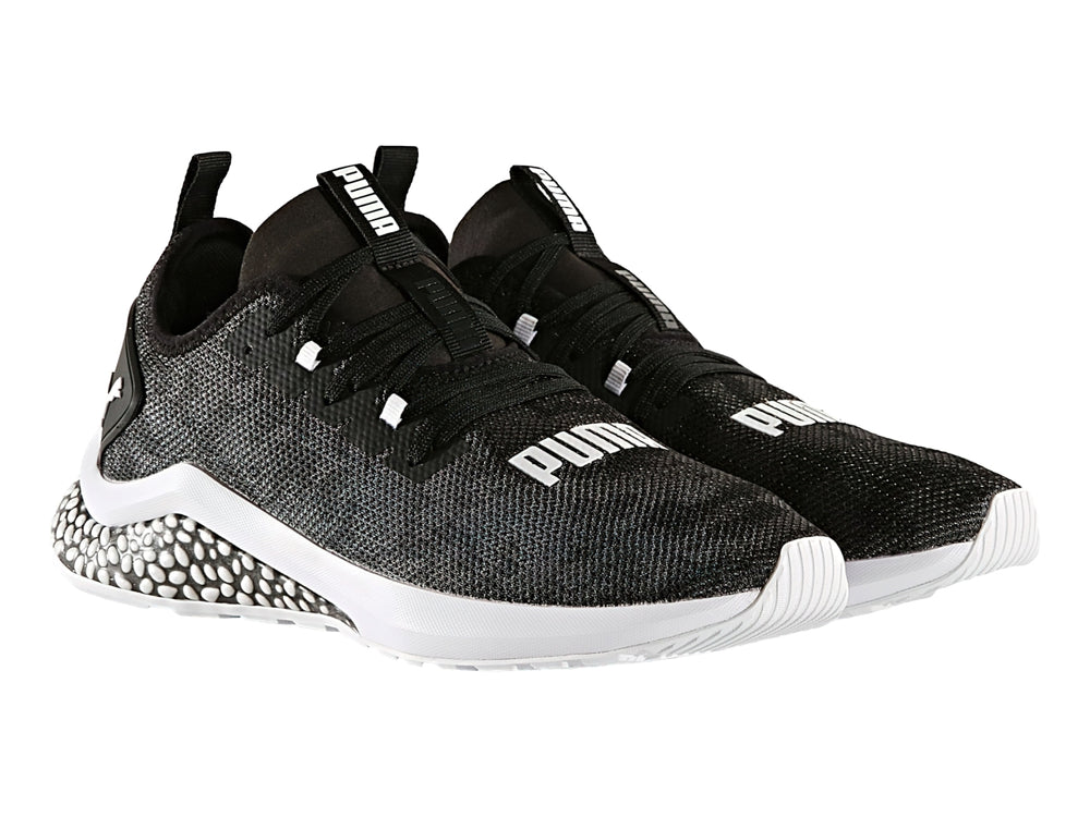 Tenis PUMA HYBRID NX color negro con suela blanca y diseño moteado en el talón.