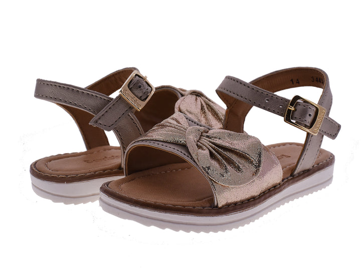 Sandalias doradas para niña con detalle de moño frontal y correa ajustable con hebilla.