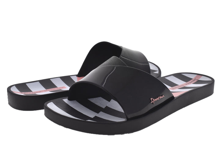 Sandalias Ipanema negras con rayas blancas en la plantilla y correa brillante.