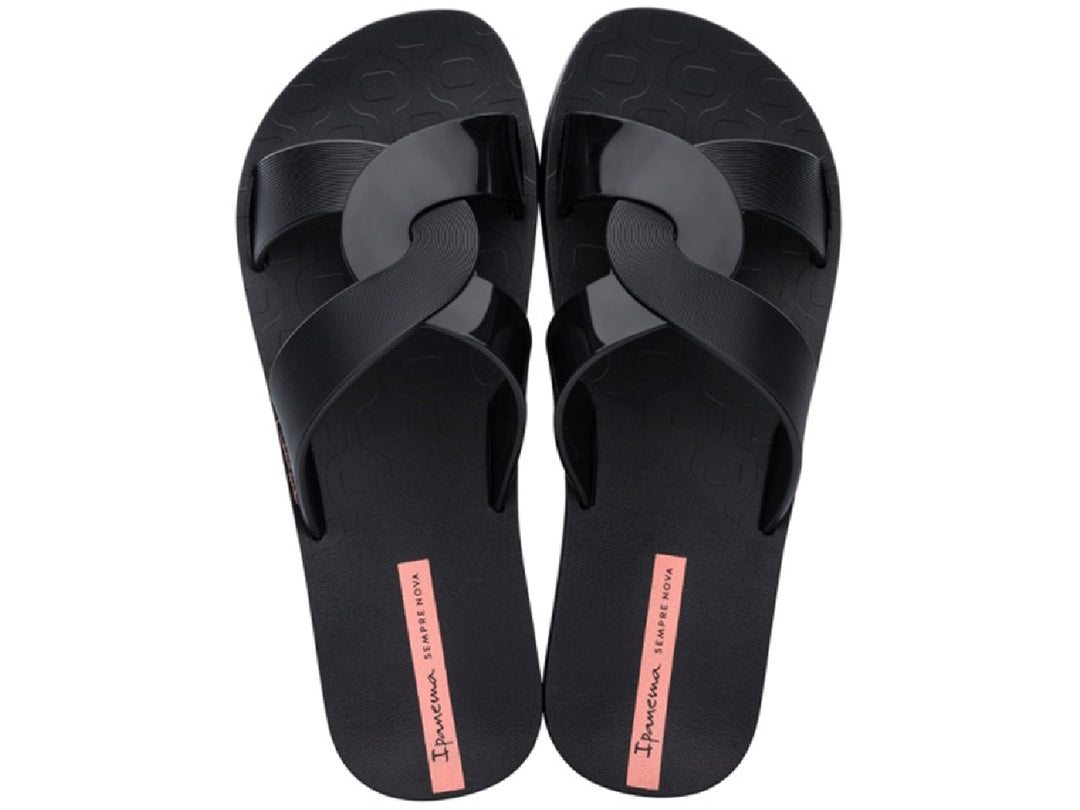 Par de sandalias negras para mujer con tiras cruzadas y suela plana.