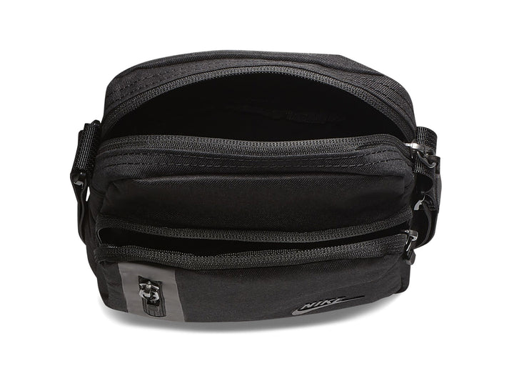 Bolso pequeño Nike Tech de color negro con correa ajustable y cierres frontales.
