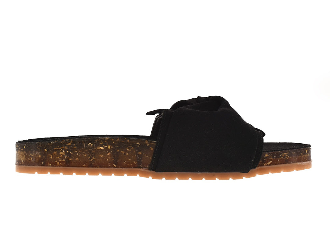 Sandalias negras con correa anudada y suela translúcida color ámbar.