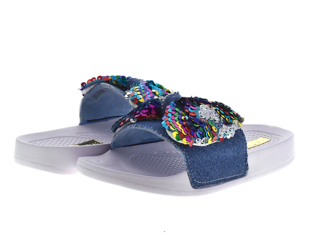 Sandalias de mezclilla azul con moño de lentejuelas multicolores y suela gris.