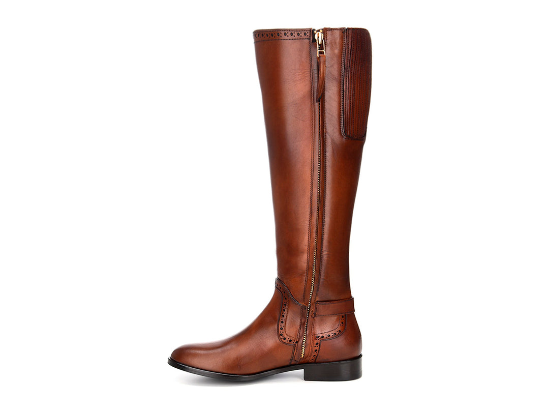 Bota alta de cuero color miel con detalles perforados y hebilla lateral.