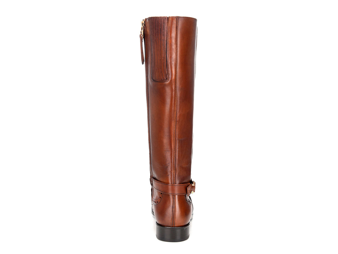 Bota alta de cuero color miel con detalles perforados y hebilla lateral.