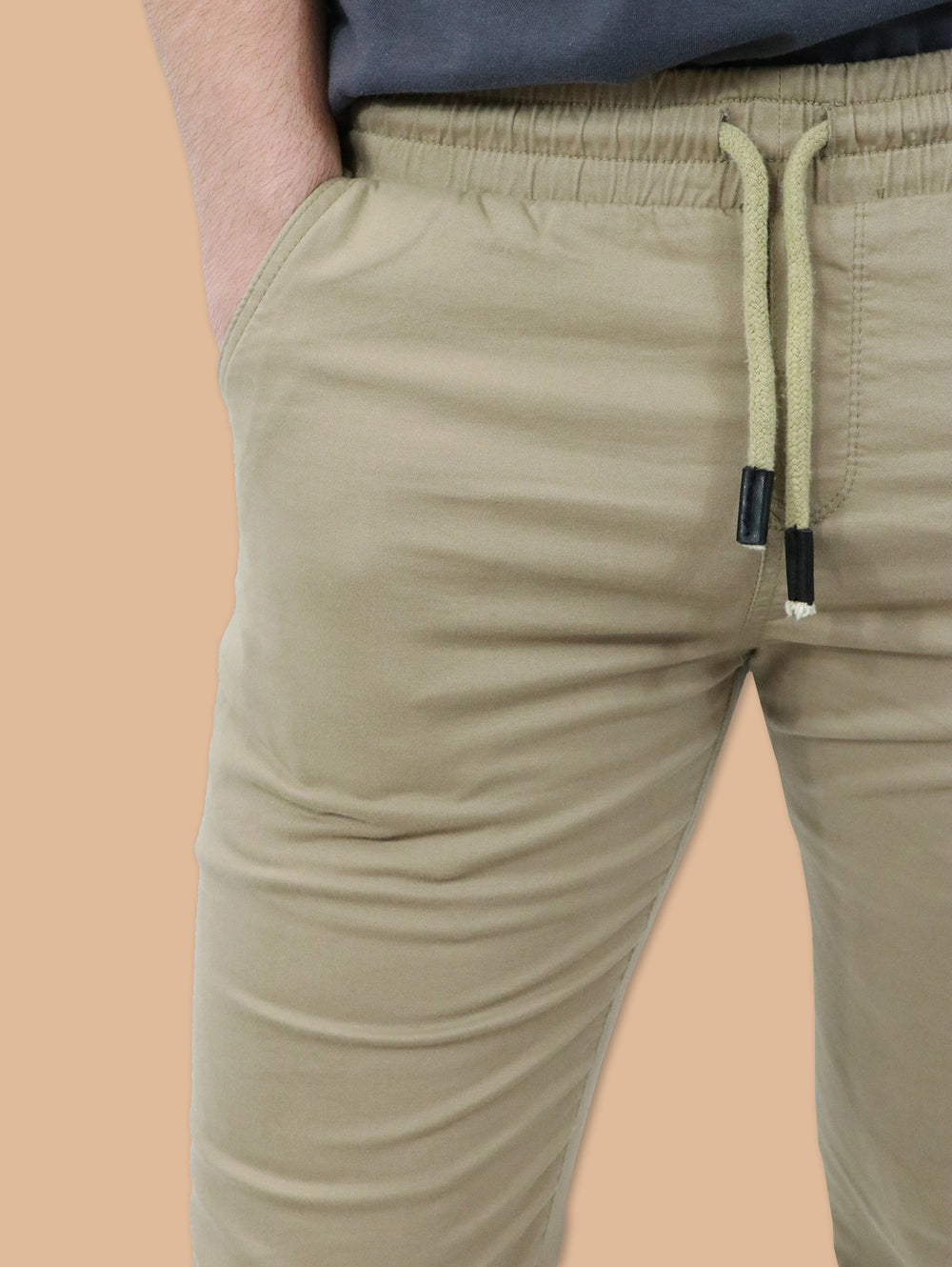 Hombre vistiendo pantalones jogger color kaki con cintura elástica y cordón