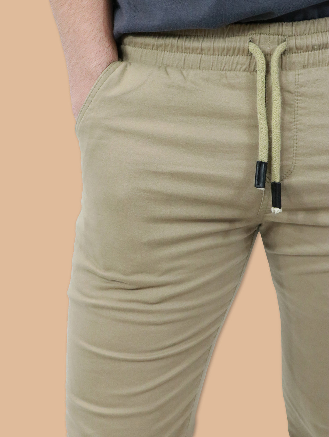Hombre vistiendo pantalones jogger color kaki con cintura elástica y cordón