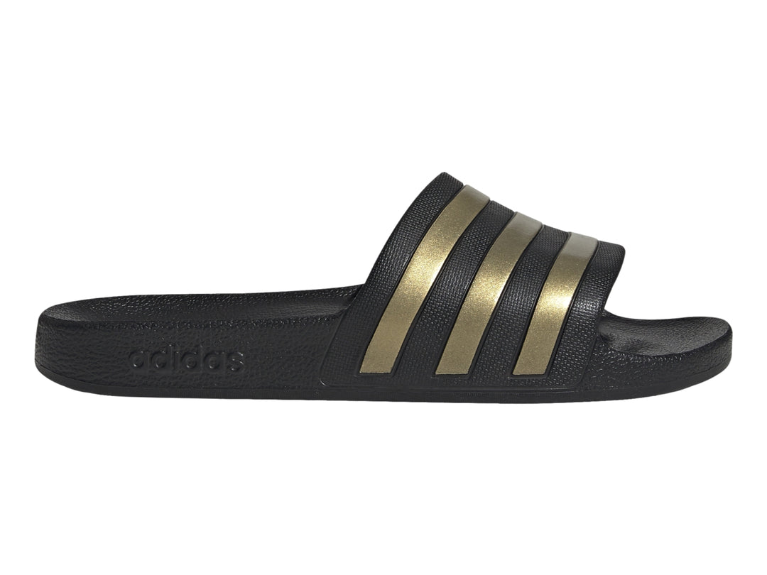 Sandalia Adidas color negro con tres franjas doradas en la correa superior.