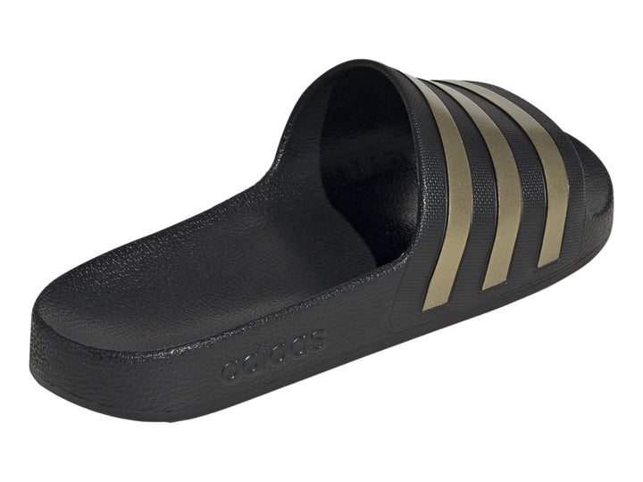 Sandalia Adidas color negro con tres franjas doradas en la correa superior.