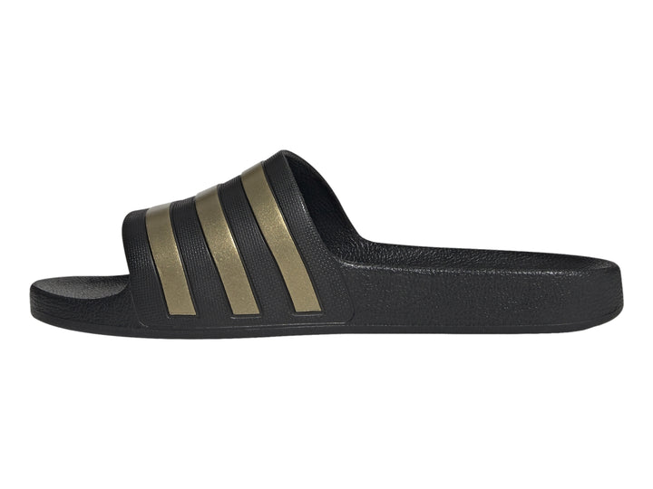Sandalia Adidas color negro con tres franjas doradas en la correa superior.