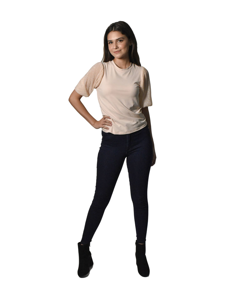 Mujer vistiendo pantalones jeans ajustados de color azul oscuro y botines negros sobre fondo blanco.