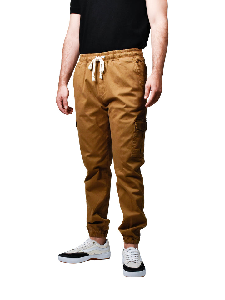 Hombre vistiendo pantalones joggers color oro con cintura elástica y cordones blancos.