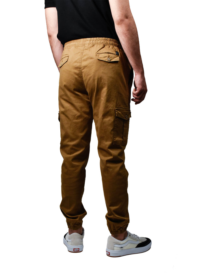 Hombre vistiendo pantalones joggers color oro con cintura elástica y cordones blancos.