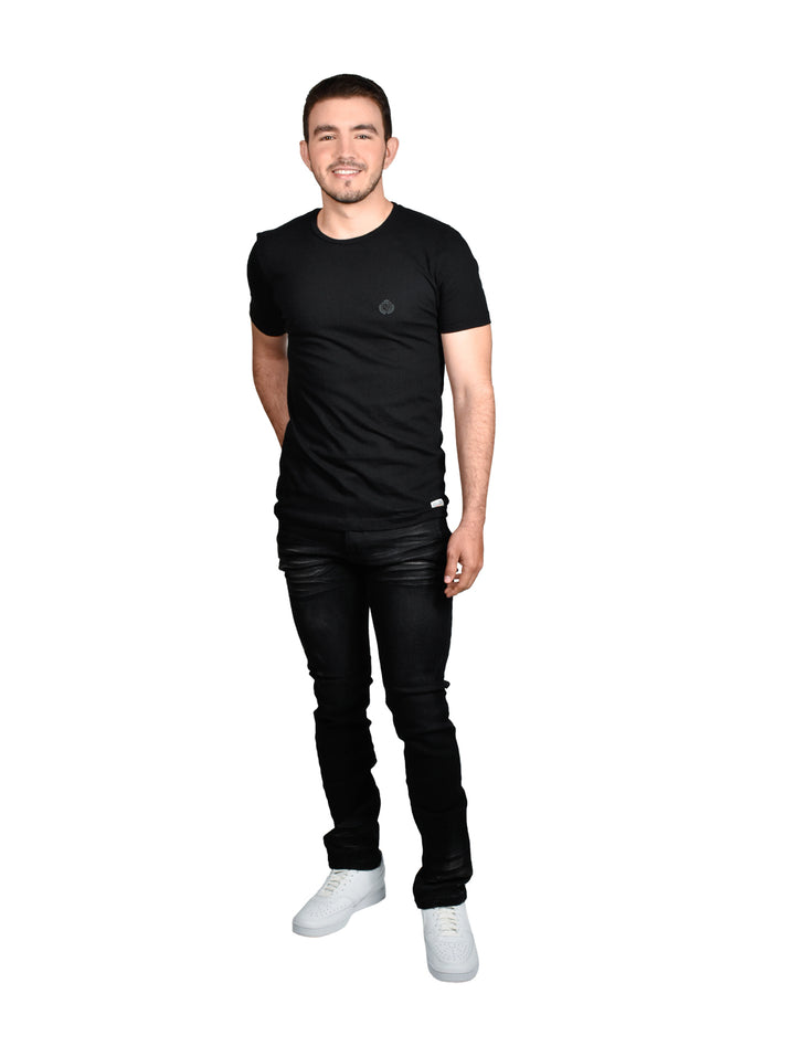 Hombre vistiendo una playera básica de color negro con cuello redondo y manga corta.