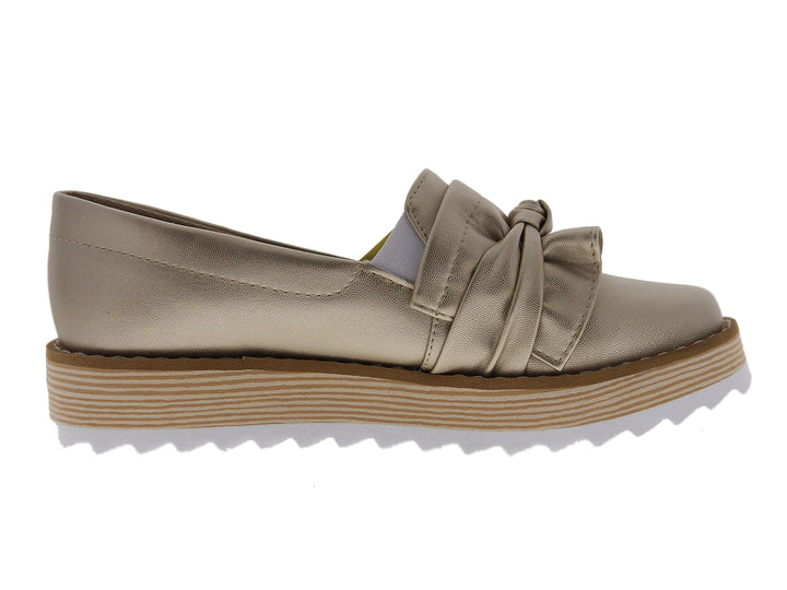 Zapatos mocasín color dorado metálico con moño frontal y suela de plataforma blanca y café.