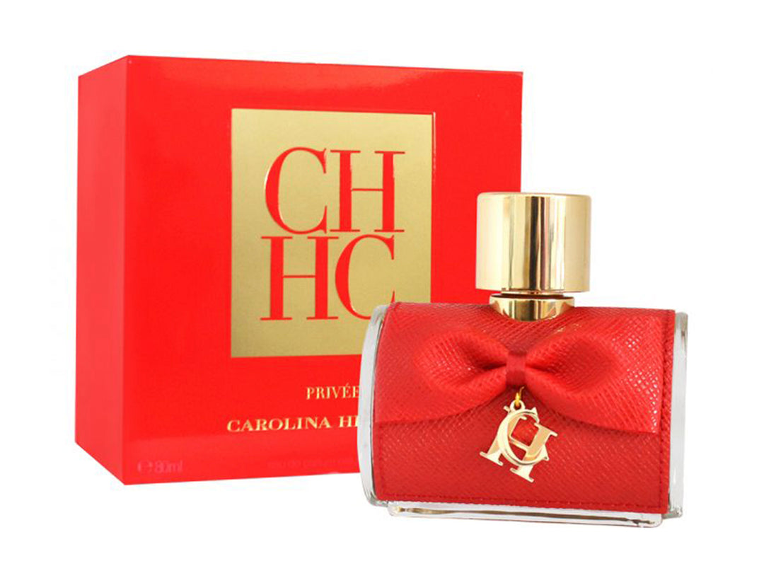 Perfume Carolina Herrera CH Privé Woman en botella roja con moño y caja roja con detalles dorados.