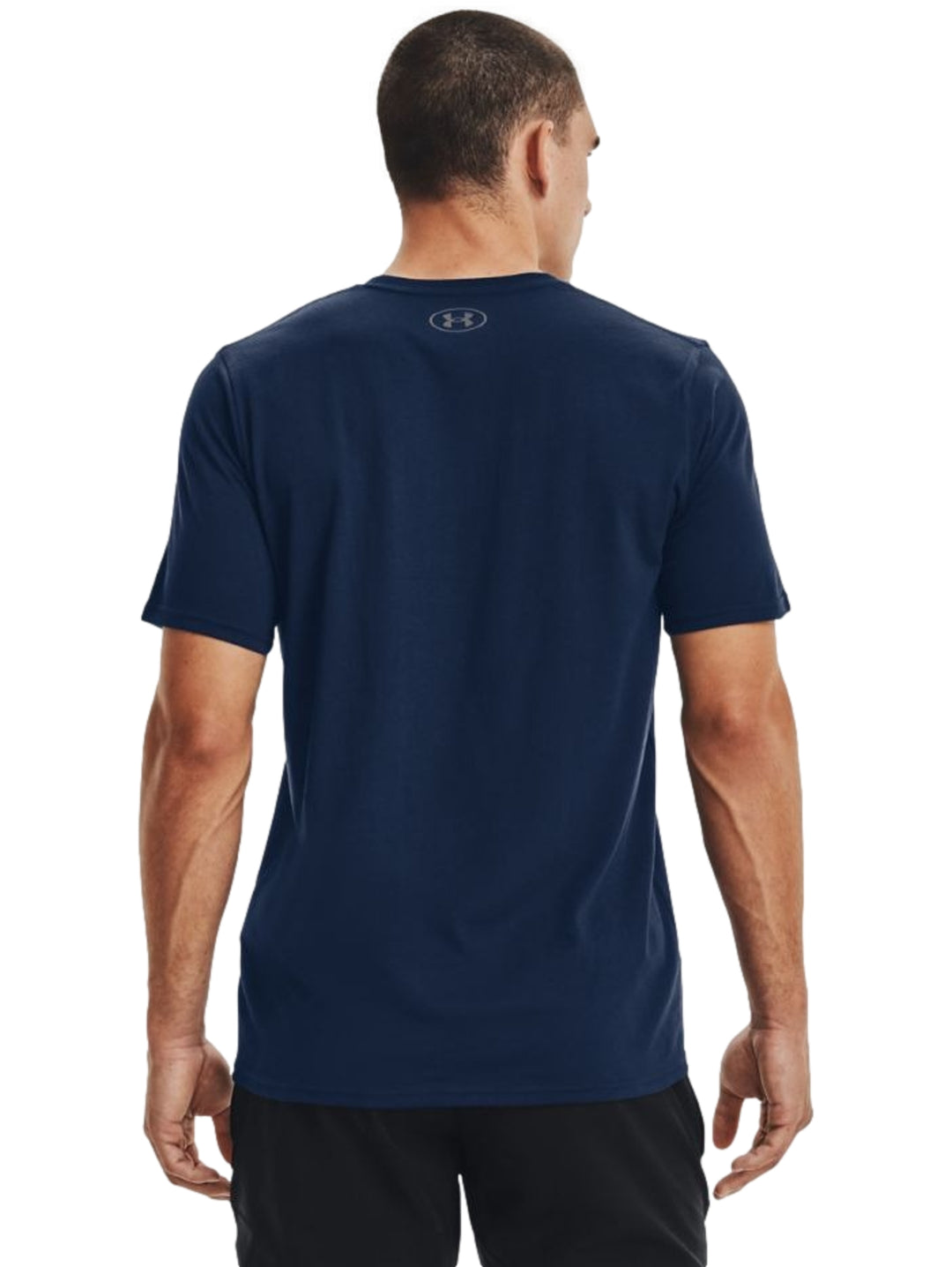 Hombre vistiendo playera deportiva Under Armour de color azul marino con logo negro en el pecho.