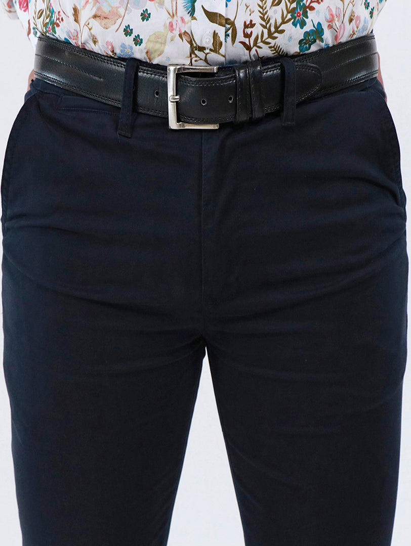 Pantalón skinny de gabardina color azul marino con cinturón negro.
