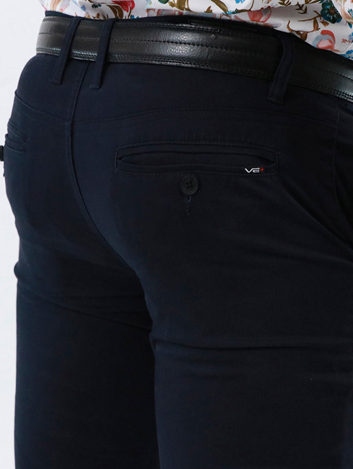 Pantalón skinny de gabardina color azul marino con cinturón negro.
