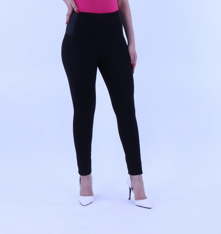 Mujer vistiendo mallas deportivas ajustadas de color negro y talle alto.