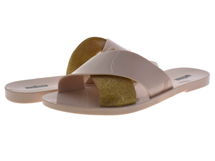 Sandalias slide Melissa color beige con detalle en dorado brillante.