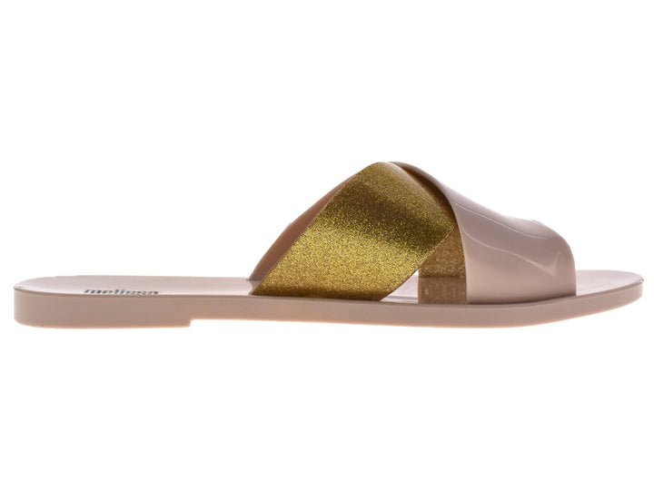 Sandalias slide Melissa color beige con detalle en dorado brillante.