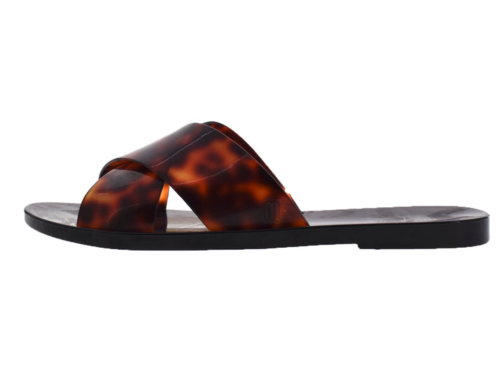 Sandalias slide Melissa negras con correas en estampado de carey brillante.