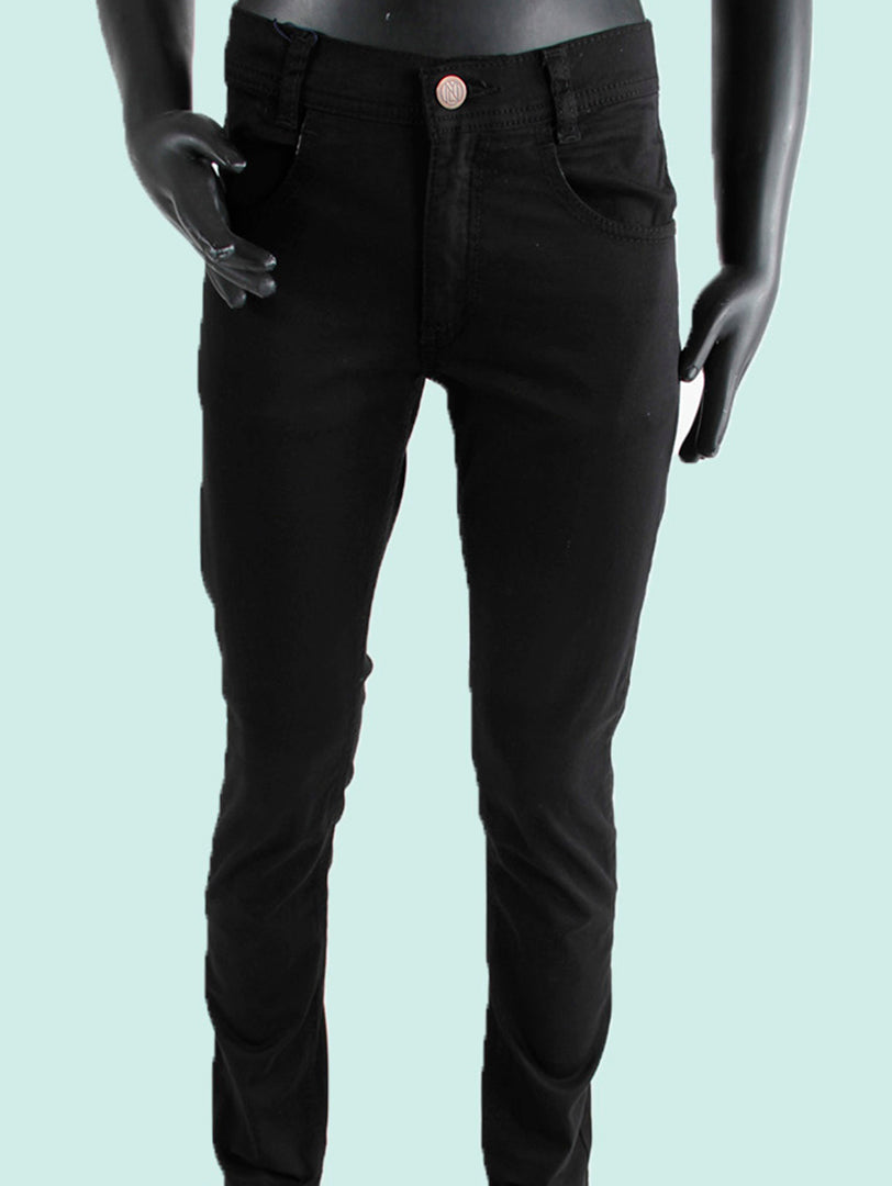 Pantalón negro para niño de corte ajustado exhibido en un maniquí.