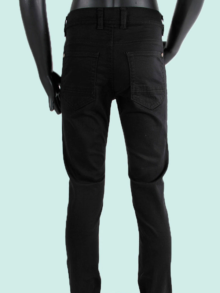 Pantalón negro para niño de corte ajustado exhibido en un maniquí.