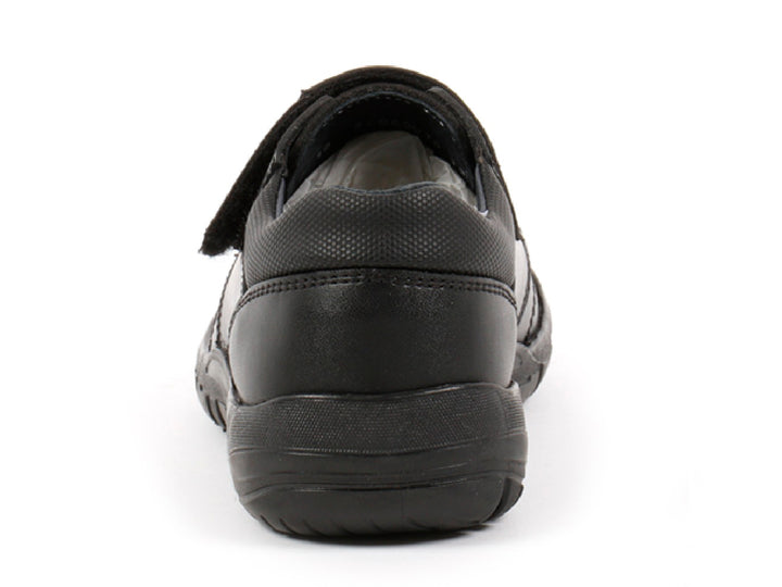 Par de zapatos negros para niño con cierre de velcro y detalles de costura roja.