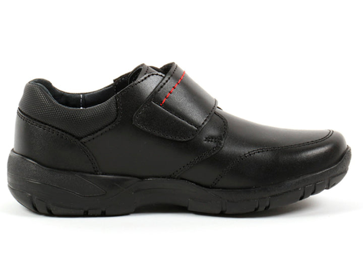 Par de zapatos negros para niño con cierre de velcro y detalles de costura roja.