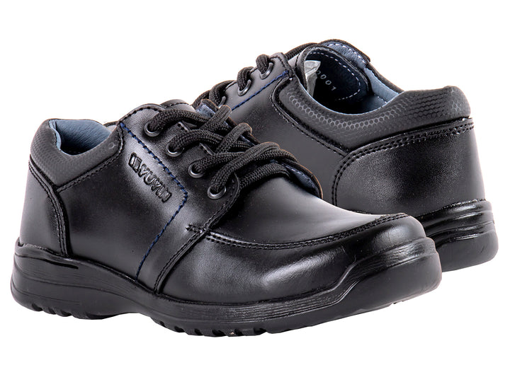 Par de zapatos negros para niño de material sintético con agujetas y suela negra.