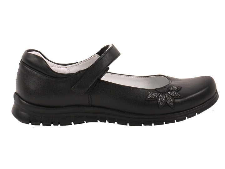 Par de zapatos negros para niña con correa y detalle floral en la punta.
