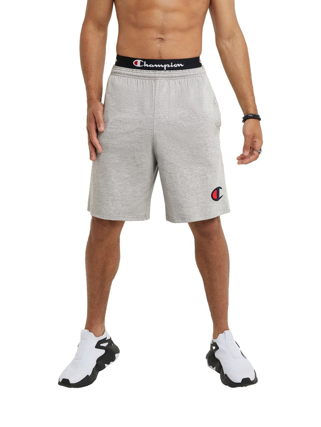 Hombre vistiendo shorts deportivos Champion en color gris oxford con cinta negra en la cintura.