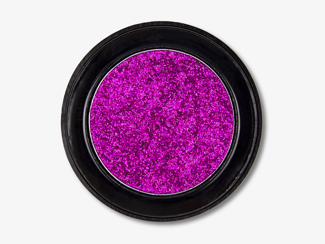 Sombra de ojos glitter color magenta en envase circular negro.