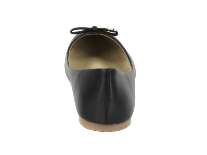 Zapato plano color negro con un pequeño moño decorativo en la punta y suela beige.