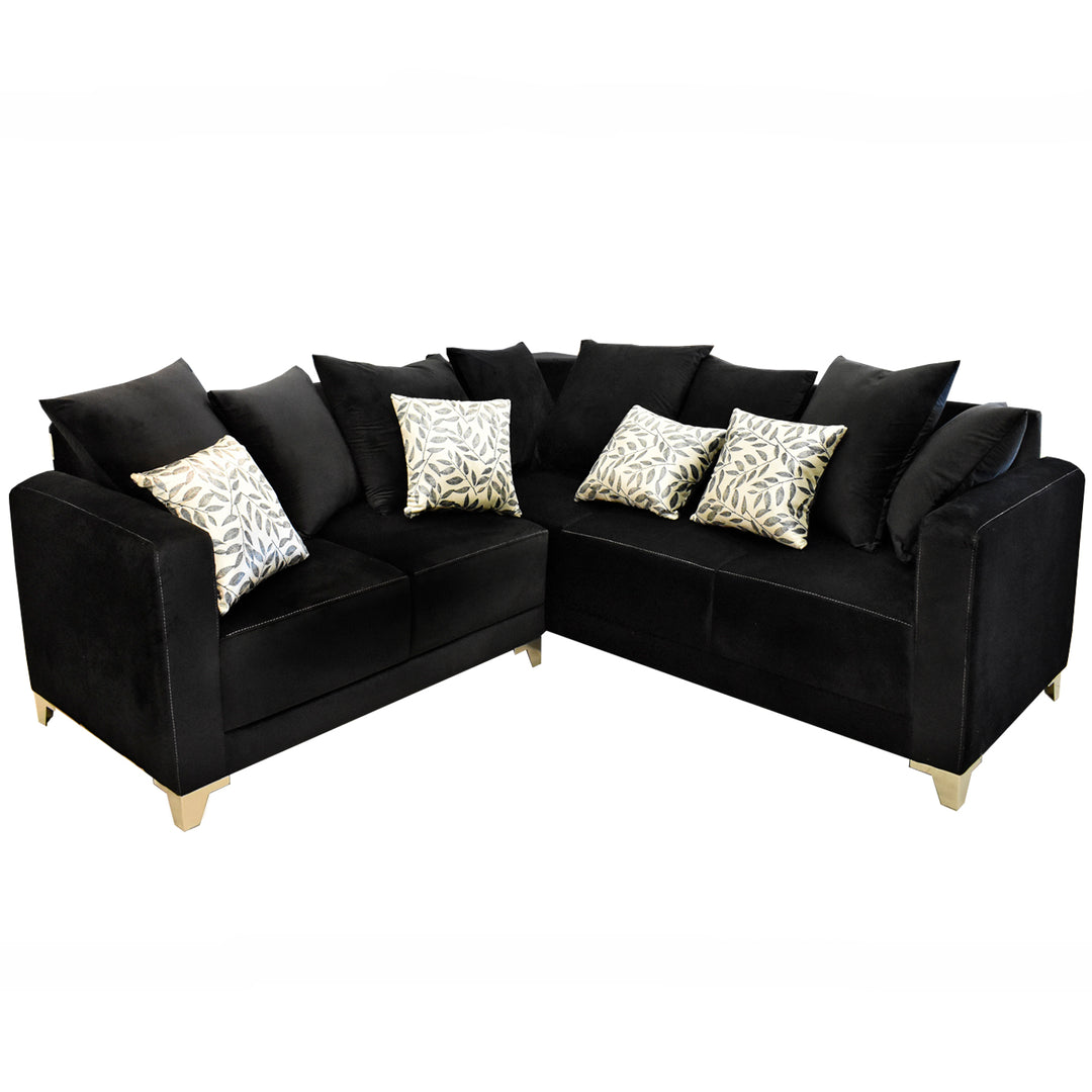 Sofá esquinero color negro con cojines decorativos estampados y patas doradas.